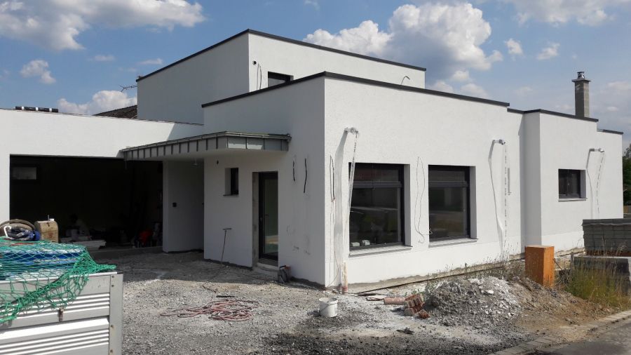 Bungalov s dokončenou bílou fasádou před předáním
